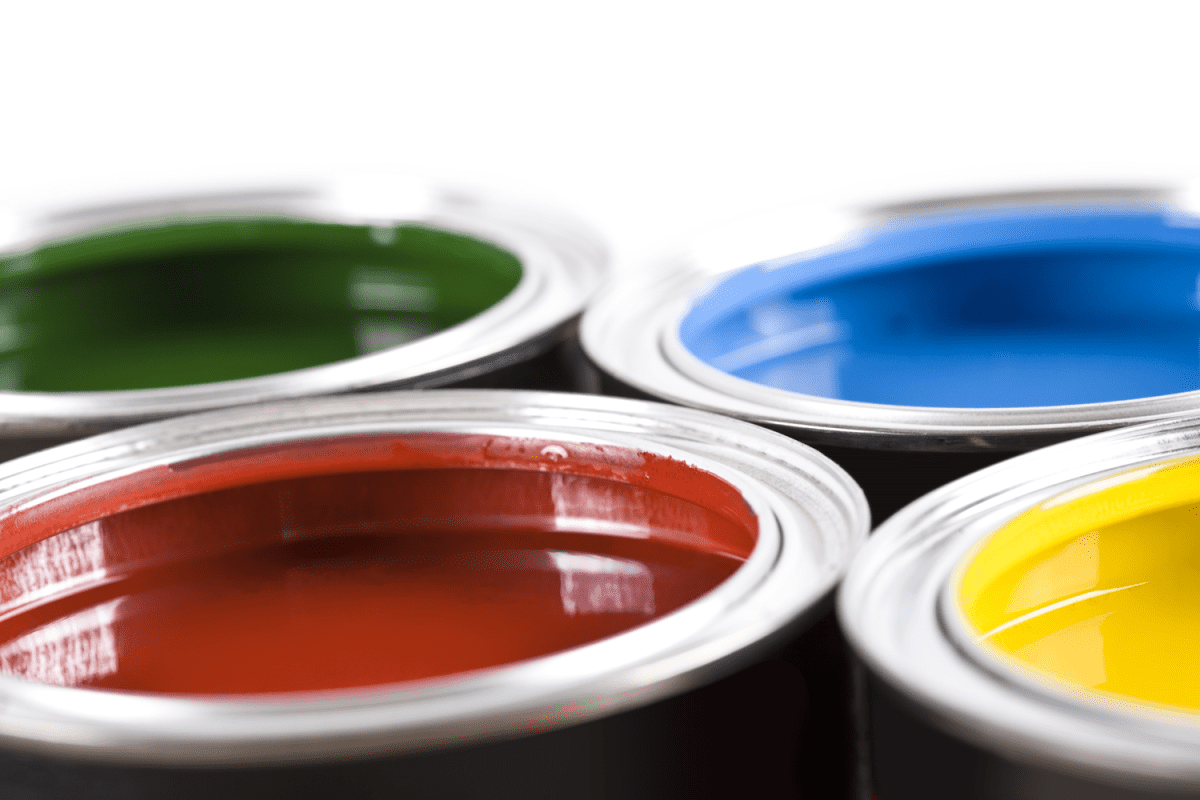 Different cans of paint opened on a white background