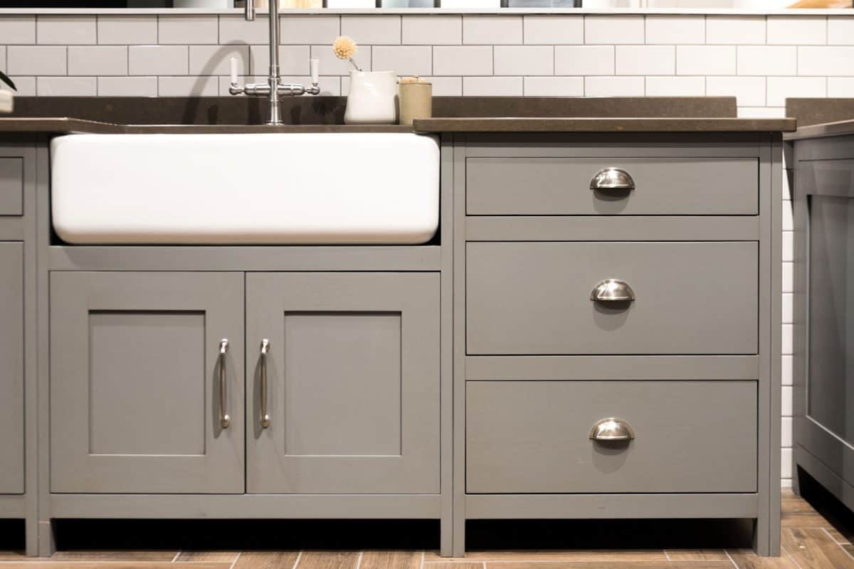 Gray painted kitchen cabinets with stainless steel handles