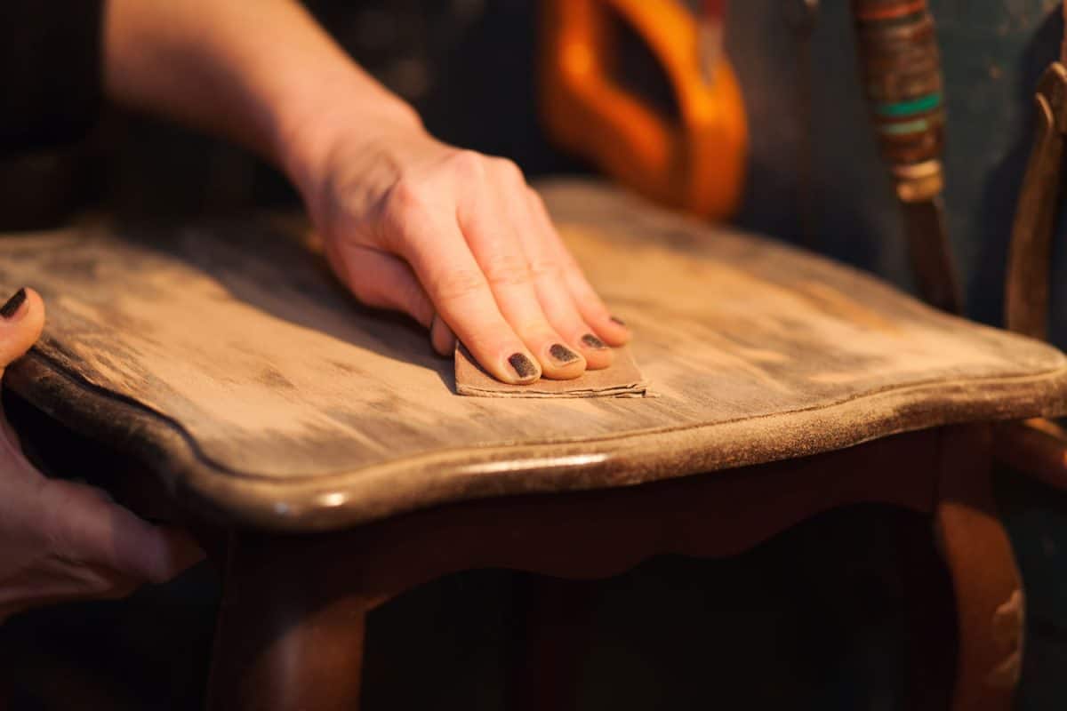 Man sanding his wooden table for a smoother finish
