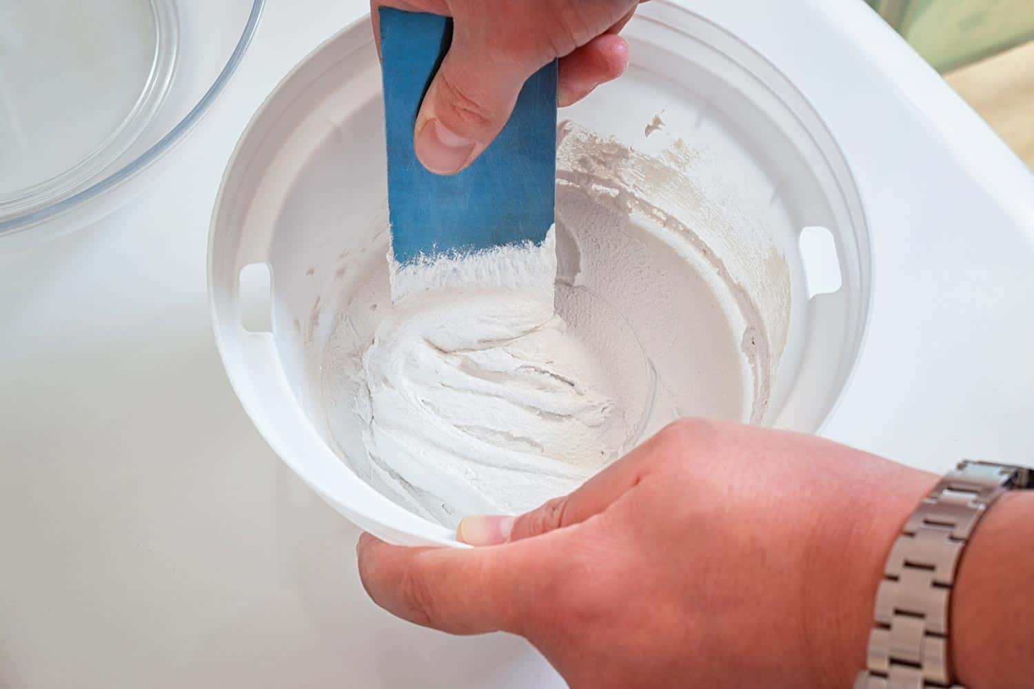 Man's hands mixing two-component grout for house maintenance