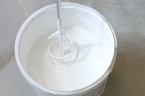 White paint in bucket on the floor ucket with white paint indoors