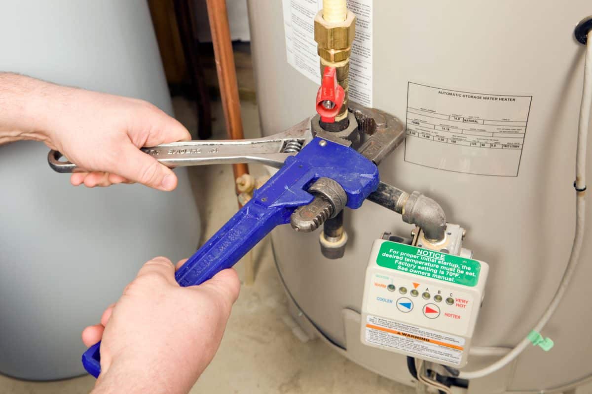 Worker opening the valve of the gas water heater
