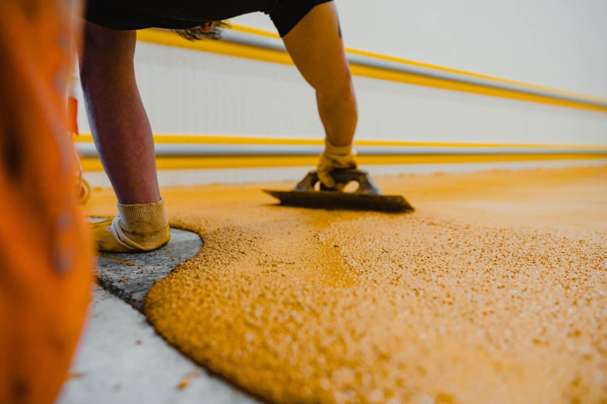 Worker spreading polyurethane and epoxy to the flooring
