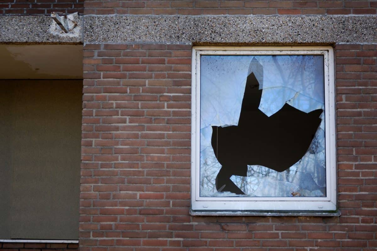 A broken glass window of a brick constructed building