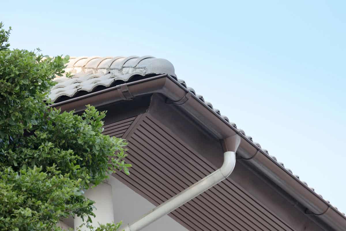 Rain gutter on top of roof against blue sky