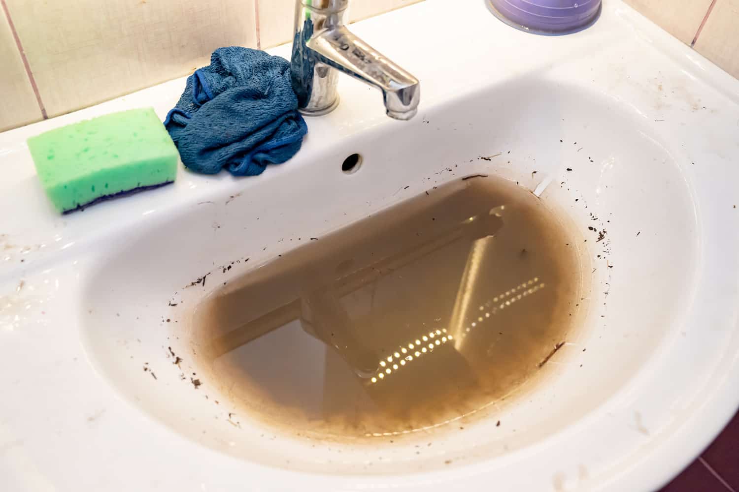 Sink with dirty water because of the blockage.