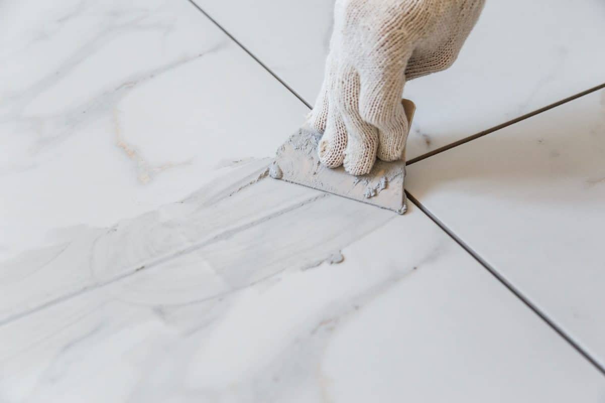 Worker using a palette to spread the tile grout