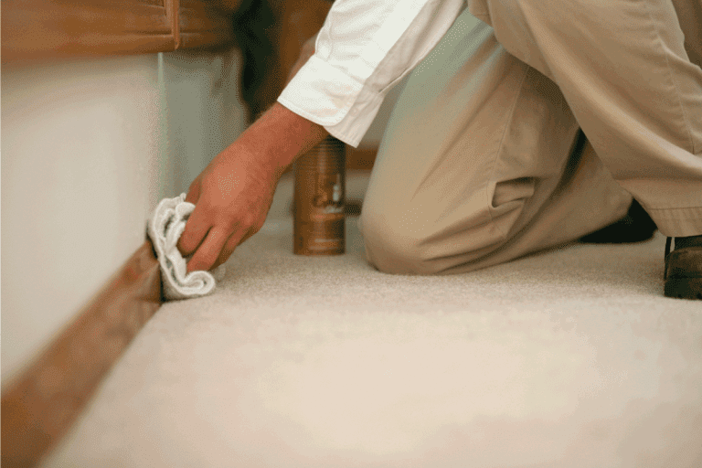 man wiping rag on newly installed baseboard. What Size Nails For Baseboard