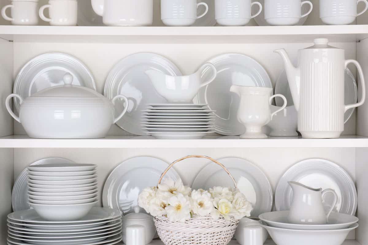 white plates and dinnerware in a cupboard