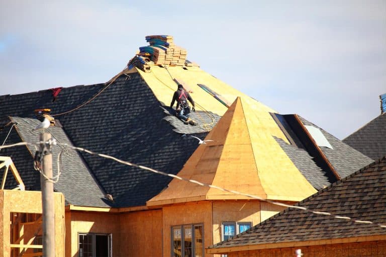 A roofer installing shingles on a new roof, How Long Can Shingle Bundles Sit On Roof?