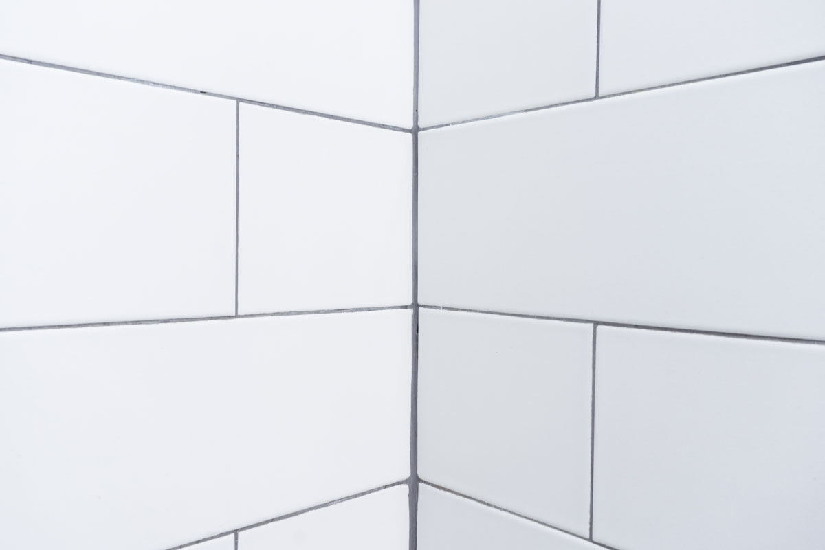 White bathroom tiles and gray colored grout