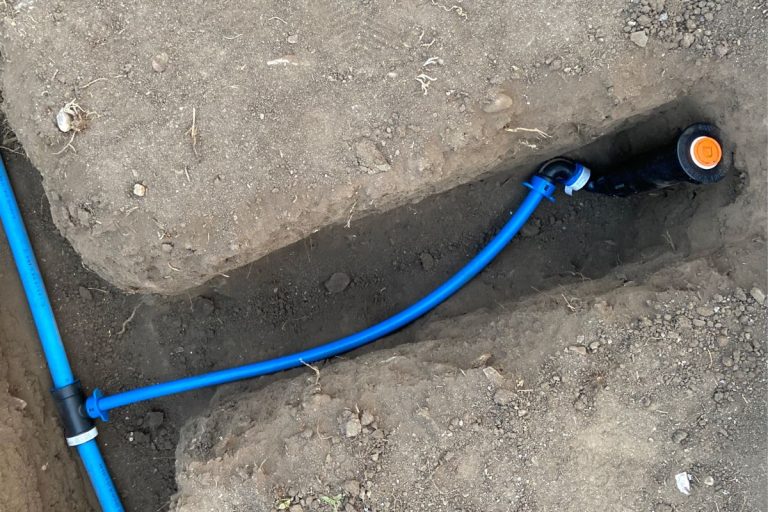 Blue sprinkler lines in trench sprinkler head. - How To Protect Pex From Sunlight