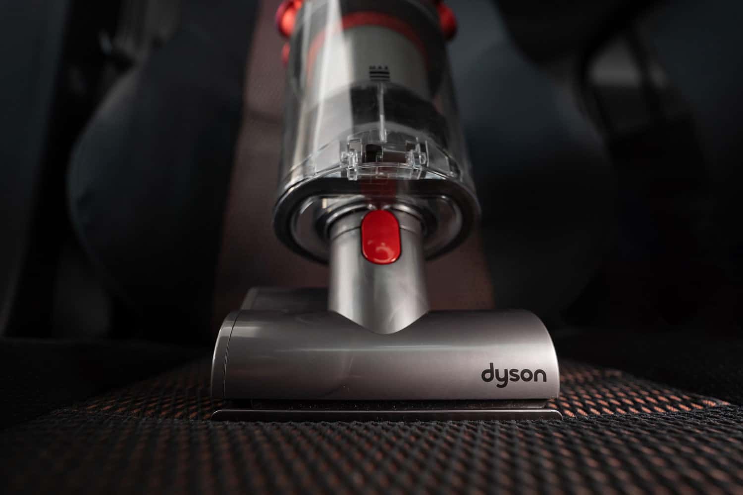 Close up of the Mini motorhead of Dyson Cyclone V10 Fluffy vacuum cleaner on car seats with car interior background. Ready for cleaning