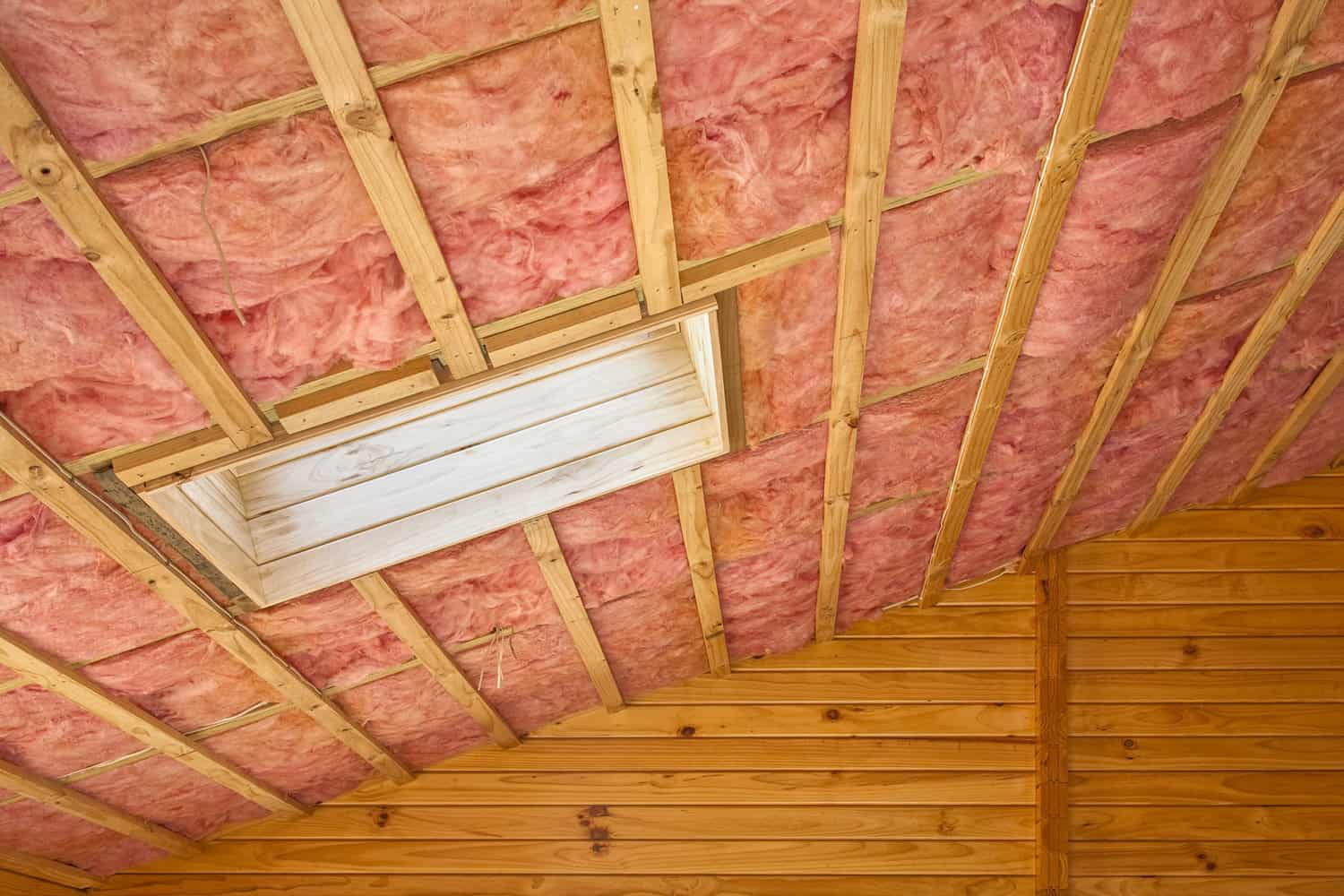 Fibreglass insulation installed in the sloping ceiling of a timber house.
