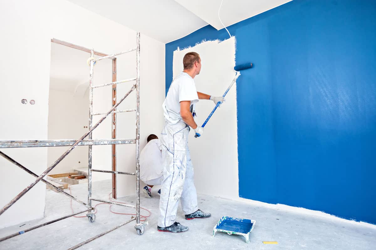 House painters beginning to paint a large blue wall