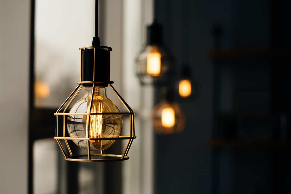 Loft style light bulbs glowing in the dark near window, Warm light, Coffee shop interior