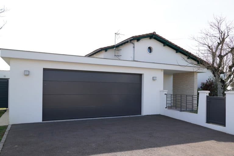 modern wide house garage door of a suburban home, How Much Weight Can A Driveway Hold?