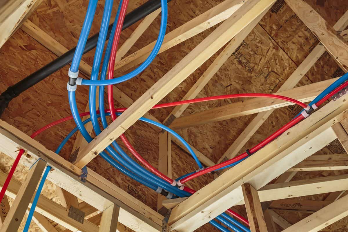 New home construction with PEX Plumbing pipes and exposed beams