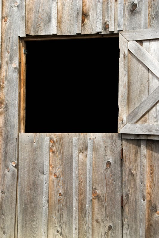 A Barn door open like a big a whole on a wood