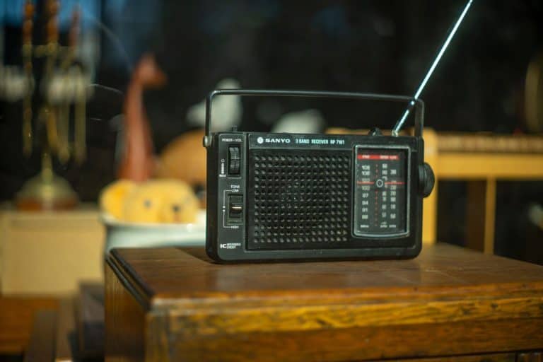 The FM channel is playing music, a stylish retro radio player stands on a wooden table. stylish kitchen in the village, daylight from the window. - How To Improve Am Radio Reception At Home?