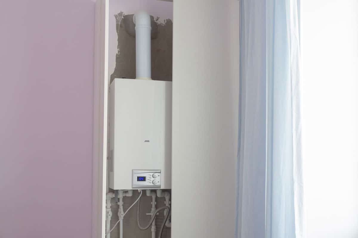 A double-circuit boiler for heating in a residential building is hidden in a white cabinet to be invisible in the interior