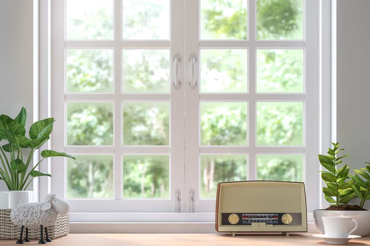 Wood shelf located by the window 3d rendering image. Decorate with vintage radio. There are white wood window look out to see the nature.