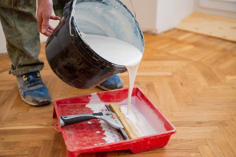 Worker pouring paint for repair into tray, How To Pour Paint Out Of A 5 Gallon Bucket