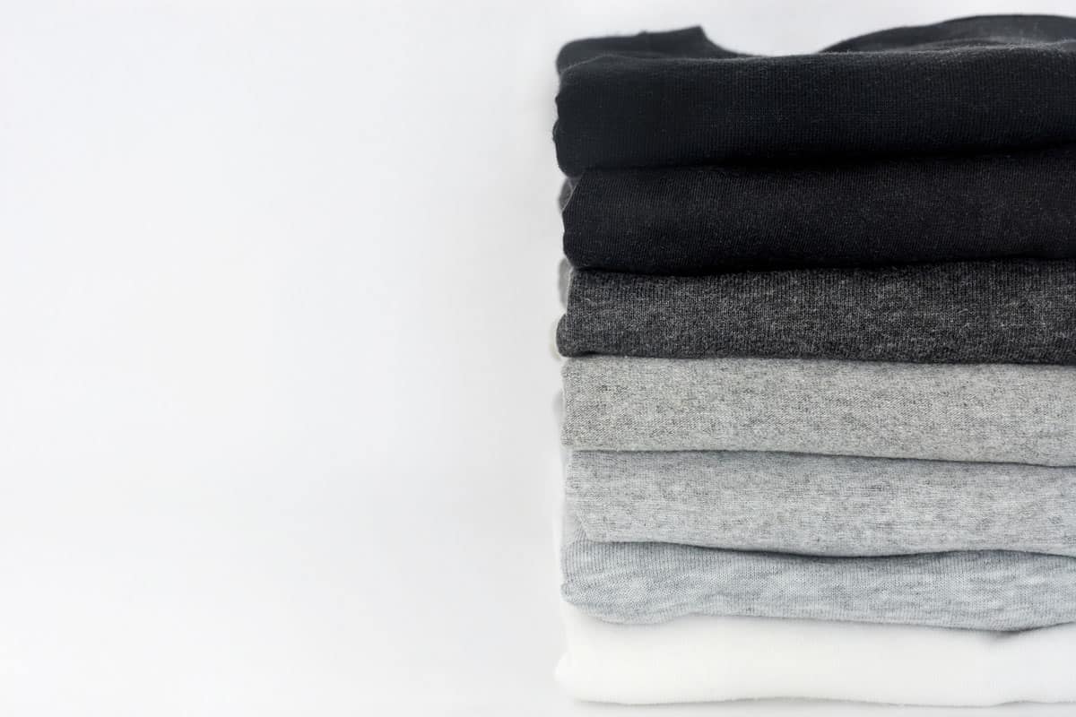 folded black, grey and white color tshirts