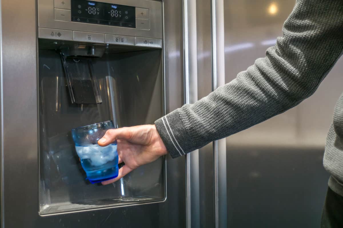 photo of a man wearing grey long sleeves getting ice and water on a whirlpool refrigerator