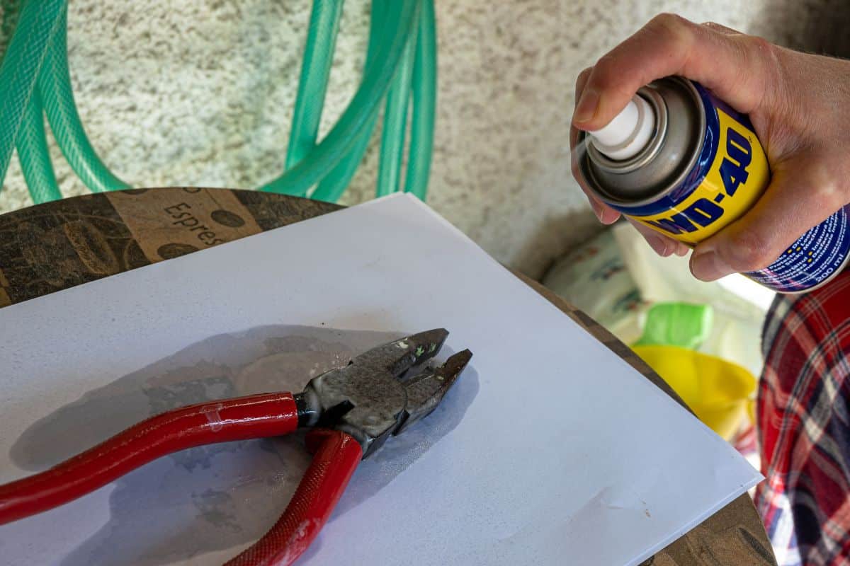 Athens, Greece-October 30,2020.A person is spraying WD-40 penetrating oil to a pliers.