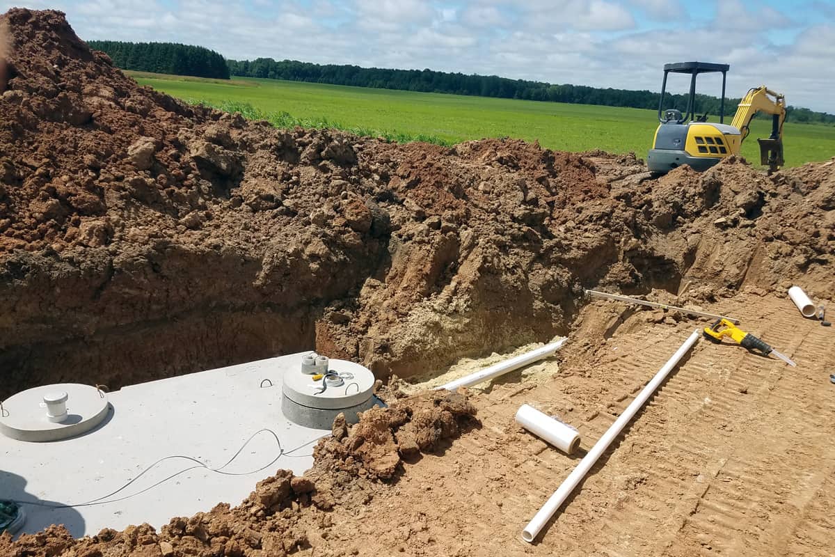 Concrete septic holding tanks being buried for a new home construction