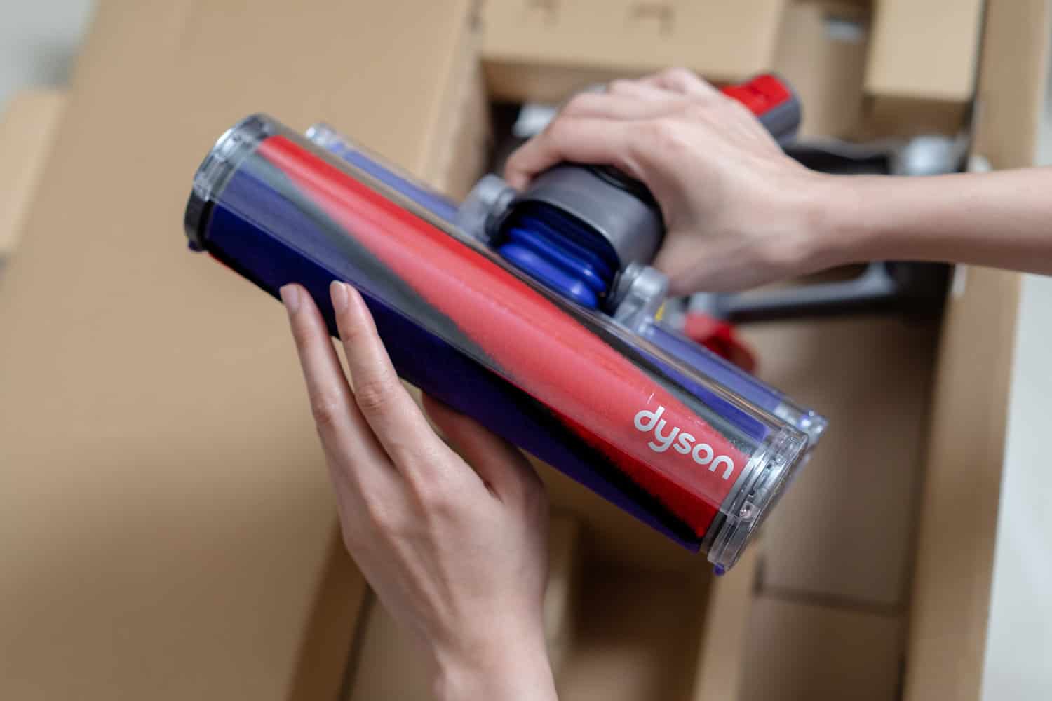 Lady’s hand holding the Soft roller cleaner head of the brand new Dyson Cyclone V10 Fluffy vacuum cleaner during open box