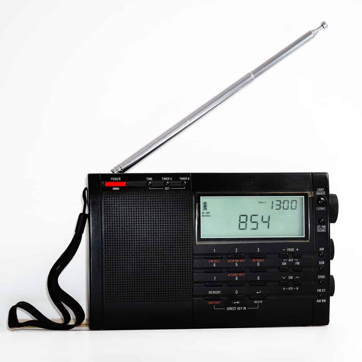 Modern black shortwave radio with antenna and digital display on a white background