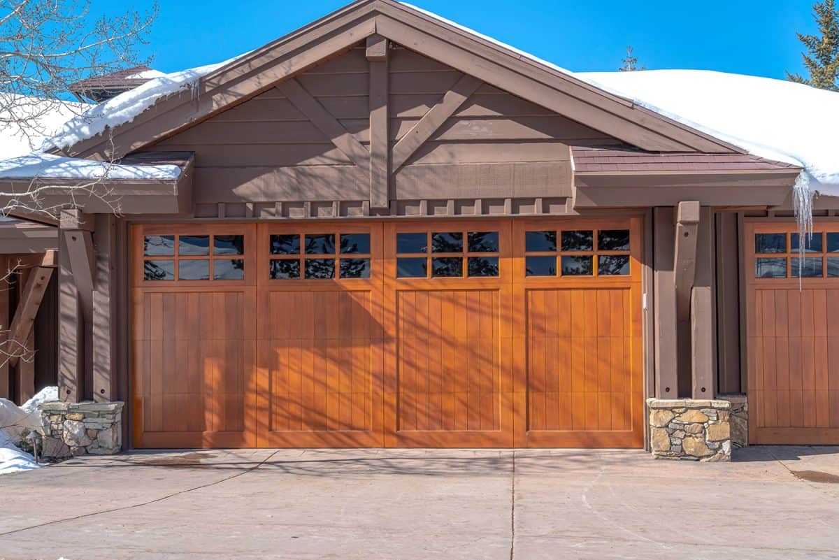 Sunlit exterior of home with glass paned brown garage door