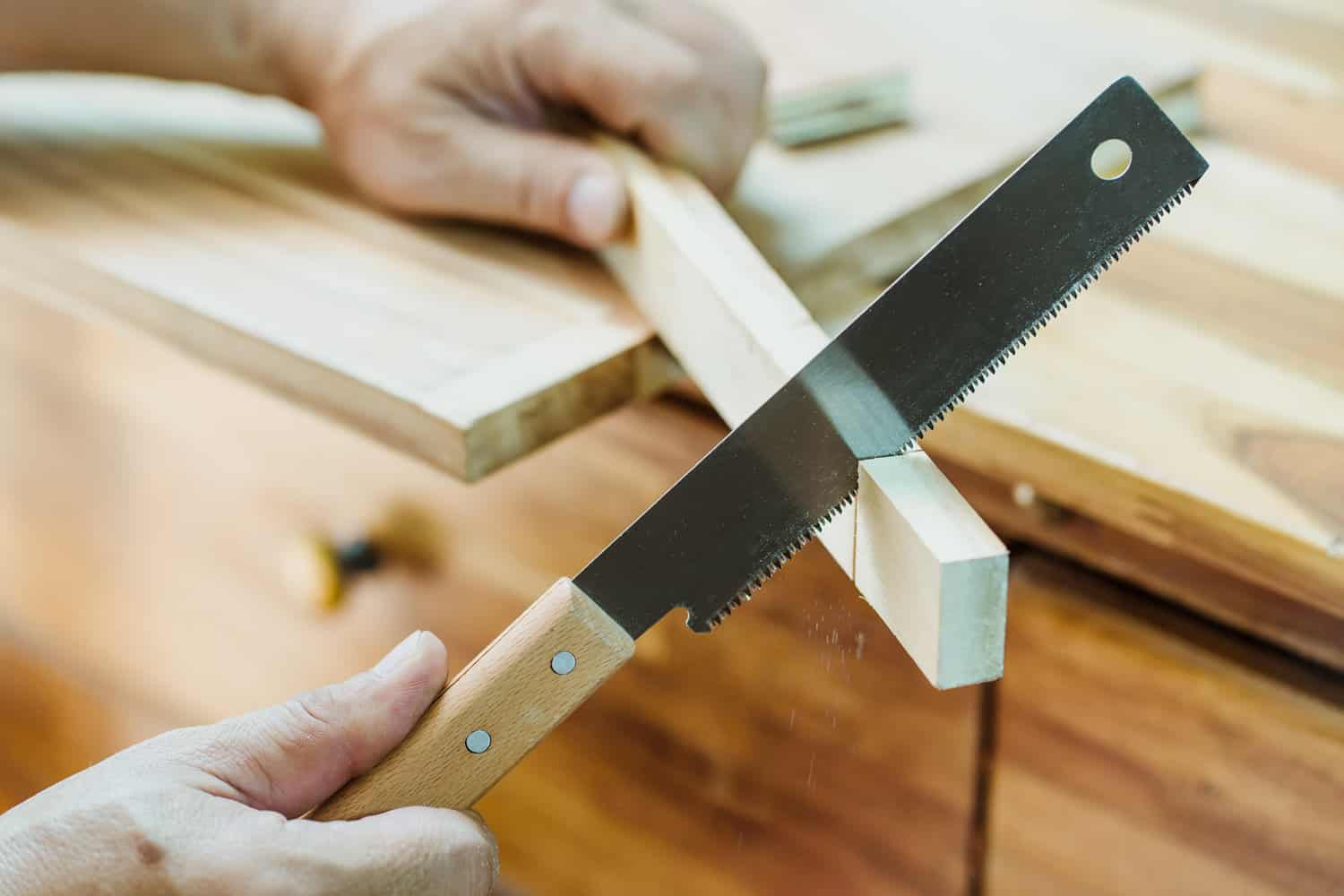 carpenter using Japanese saw or pull saw ,Crosscutting on wood on table, DIY maker and woodworking concept. selective focus