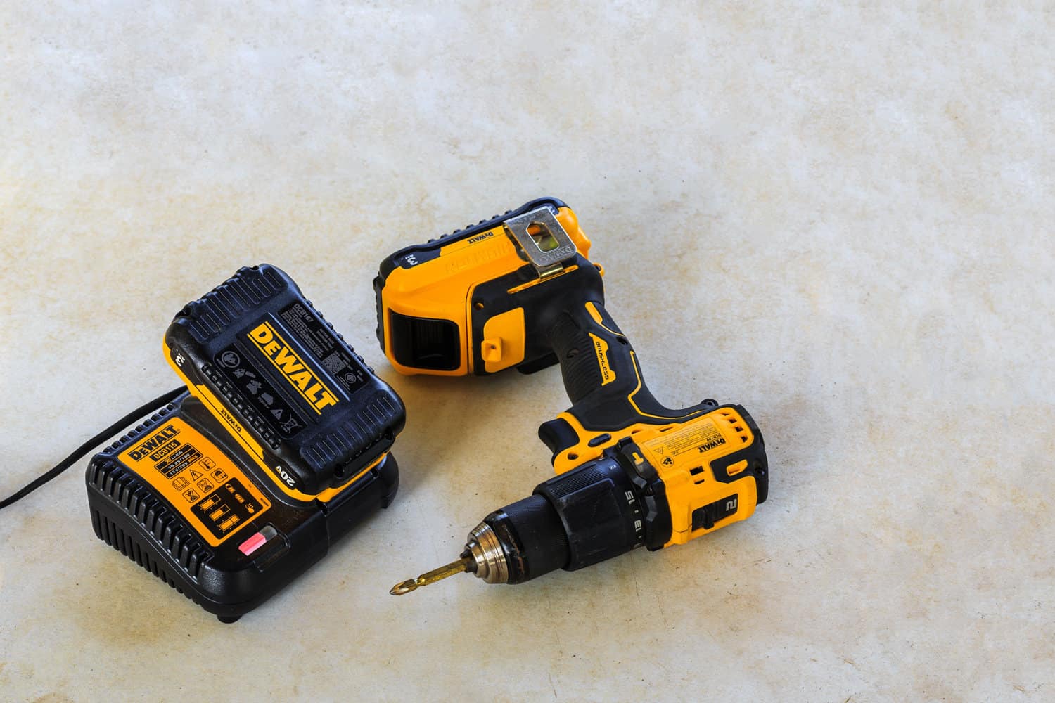 Dewalt Cordless Hammer Drill-Driver with battery charger and second battery on Cement board background