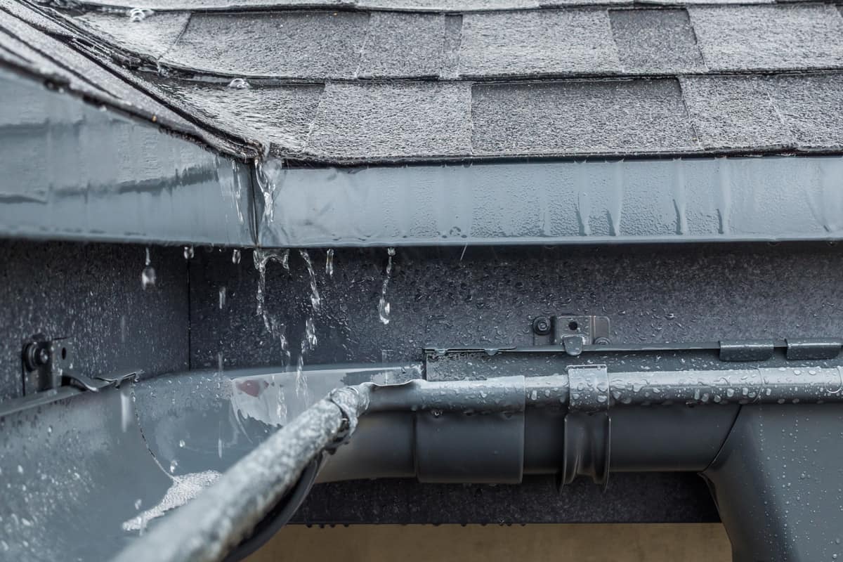 Jets of rain drain into the drainage system on the roof of the house.