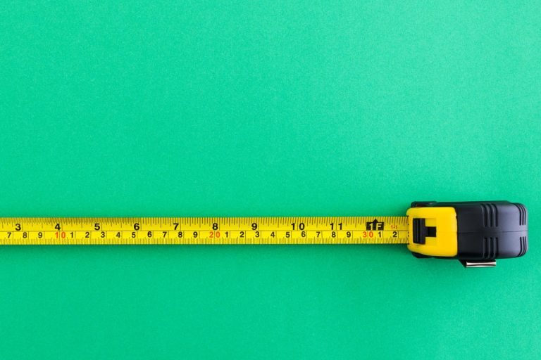 A yellow tape measure on green background, Where Is 5/8 On A Tape Measure?