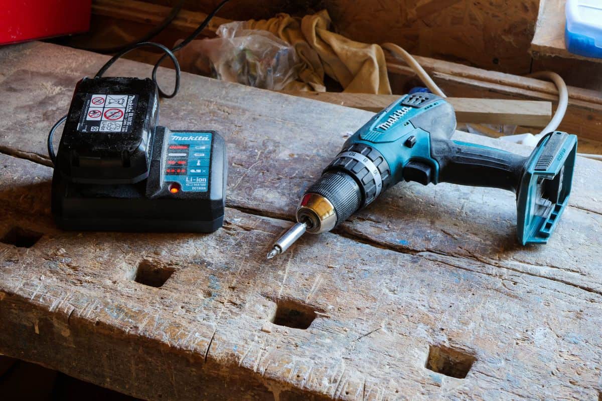 Charging Makita cordless drill battery in a small woodworking shop.
