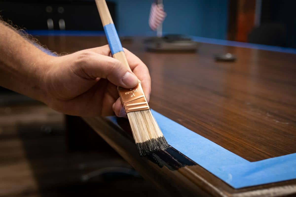 Hand painting conference table edge/trim; prepped with blue painter's tape