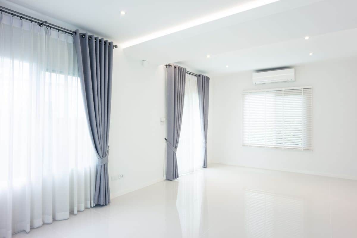 White empty space or room with ceramic tile floor in perspective view, ceiling, curtain, blind, light from door, ceiling strip light and air conditioner. 