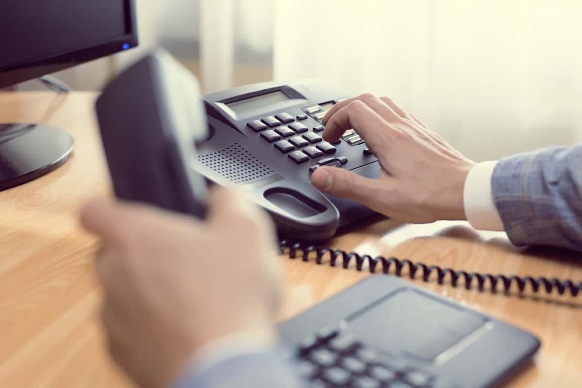 businessman dialing voip phone office keyboard