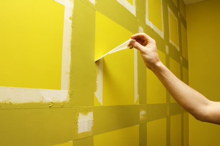 worker man removing masking tape from painting wall, Is Masking Tape Safe For Walls?