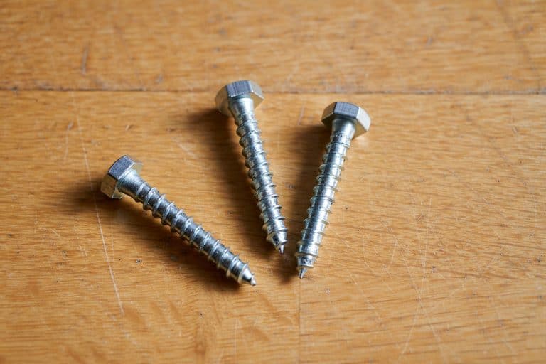 Lag bolts screws on a wooden table, Lag Screw Vs Lag Bolt: Is There A Difference?
