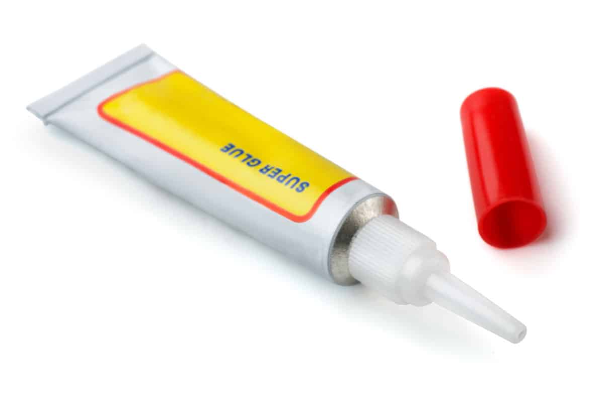 Metal tube of instant super glue isolated on white 