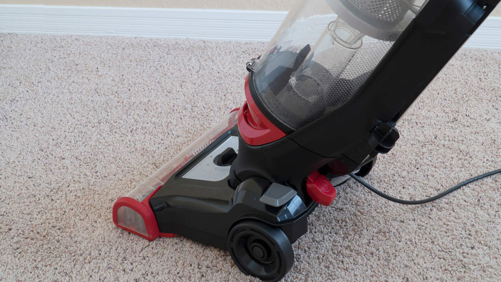 Vacuum cleaner is used to clean a carpet surface while doing household chores