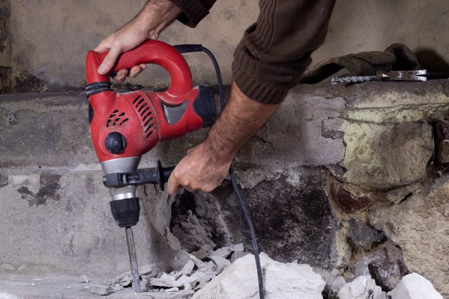 Worker using a hammer drill in a house renovation project
